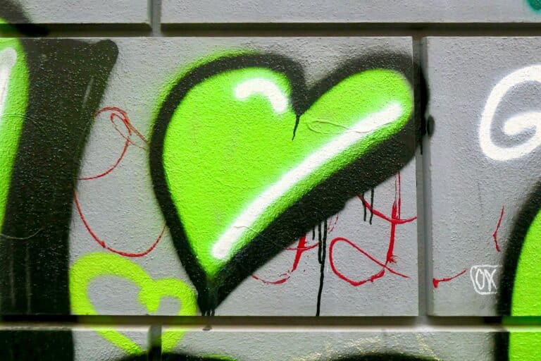 Et grønt hjerte laget i grafitti på en murvegg.