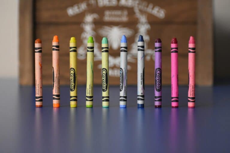 Fargestifter i merket Crayons stående på rekke og rad på et bord.