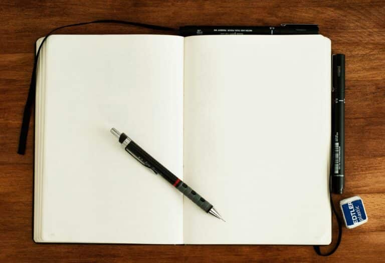 En bok som ligger åpen med en penn på midten. Det står ingenting i boken.