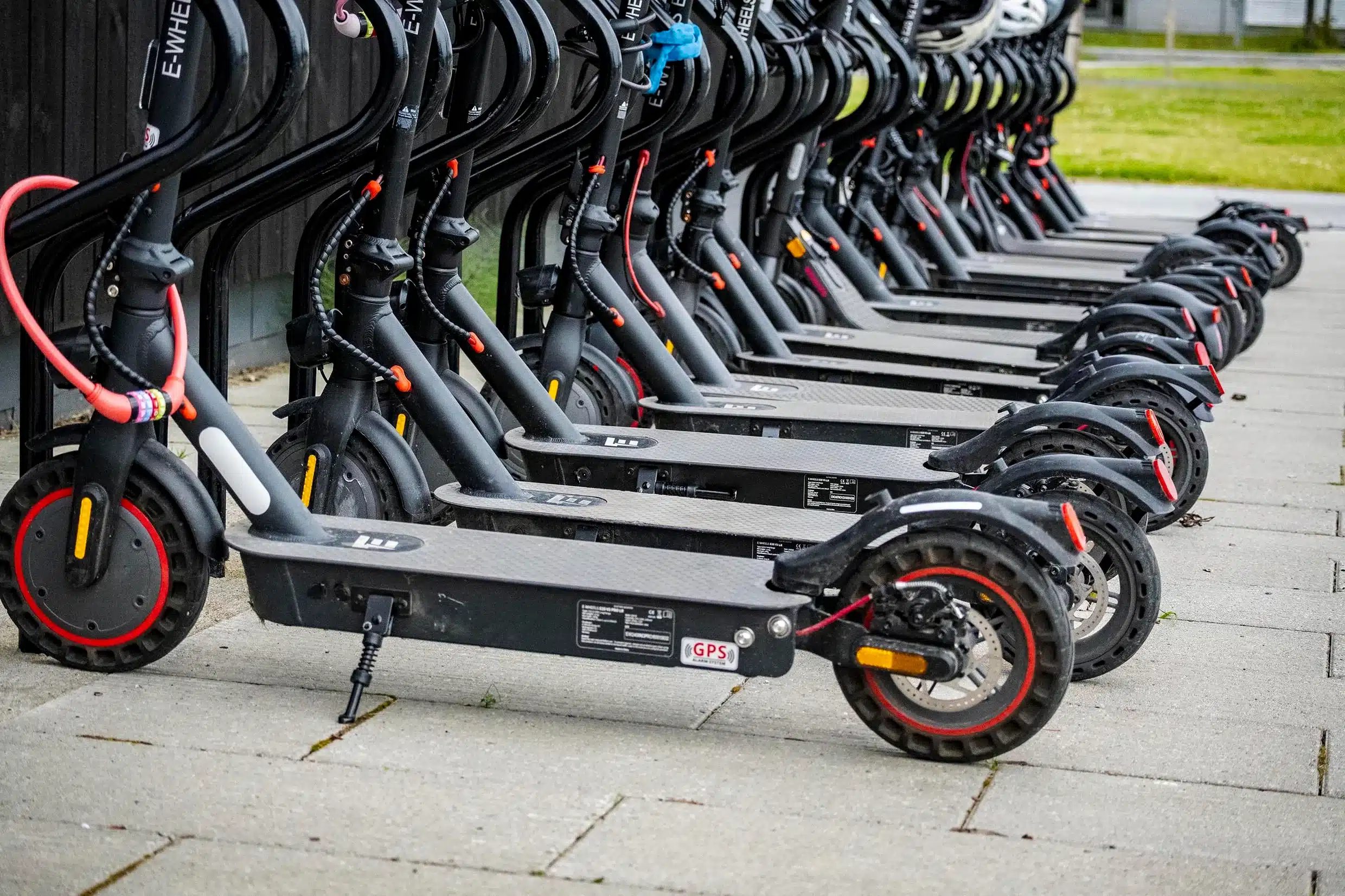 Mange parkerte elsparkesykler på rekke og rad.