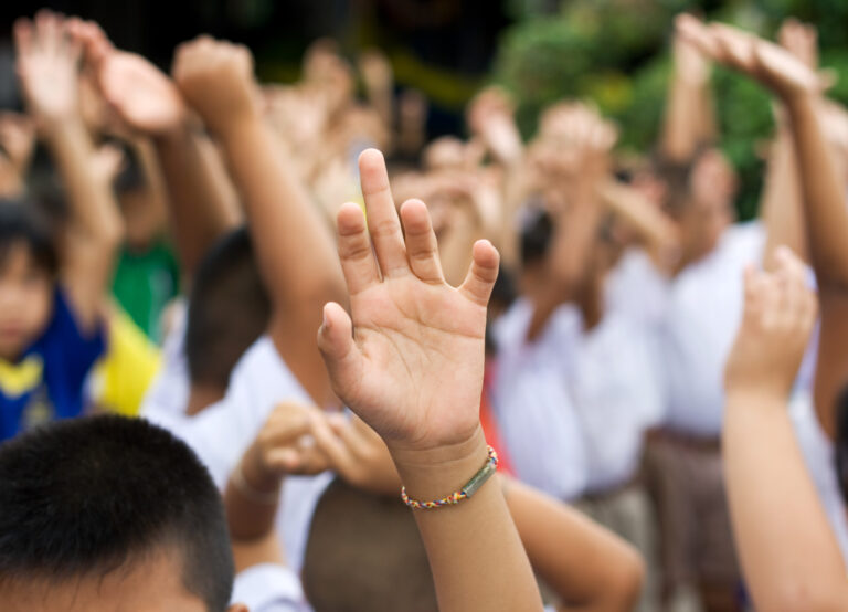 Bilde som viser elever som rekker opp hånda
