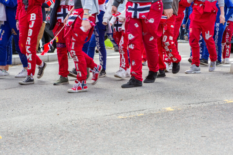 Russ i gruppe som går med russedrakt. Vi ser bare fra livet og ned.